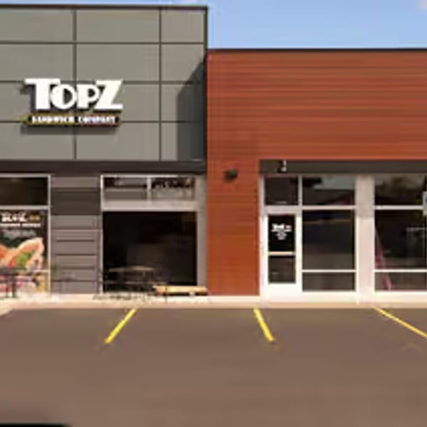 Exterior of Topz Sandwich Company, a modern restaurant with a gray and orange facade.